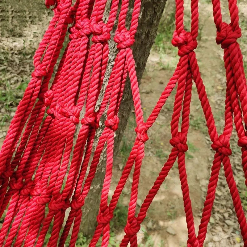 Outdoor nylon rope mesh hammock with tying strap shown in use