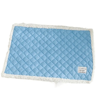 Quilted terry cloth pet blanket for cats in blue, grey, pink, or yellow colour on a pet bed.