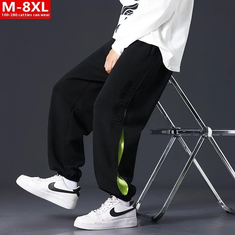 Men's ankle banded trousers in micro-elastic cotton with collage stitching details, showing loose fit and tapered leg