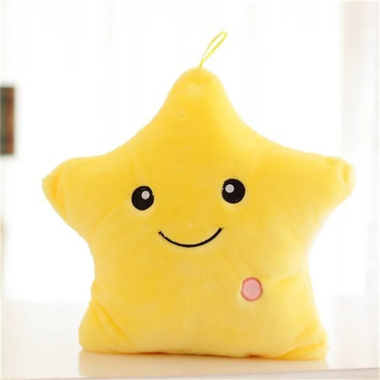 Colourful glowing five-pointed star plush pillow on a dark background.