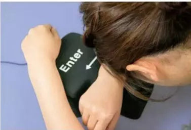 USB Decompression Enter Key Nap Pillow on a desk, showcasing its soft sponge material and USB cable.