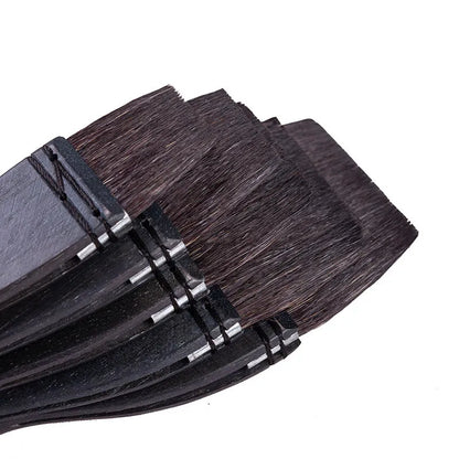 Grey squirrel hair makeup brush with a wooden handle on a plain background