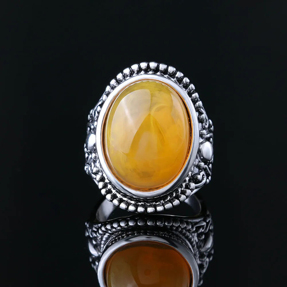 Geometric antique silver amber alloy ring with fluorescent beeswax plating on a model's finger.
