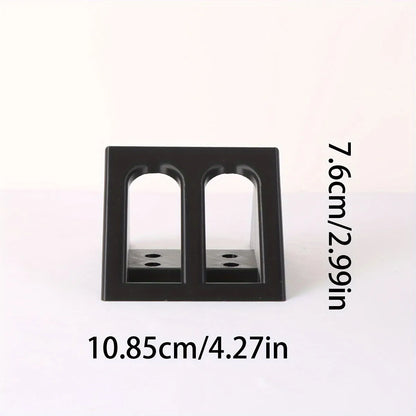 Matte black plastic punk-style pistol display stand on a wooden surface, measuring 10.85cm long.