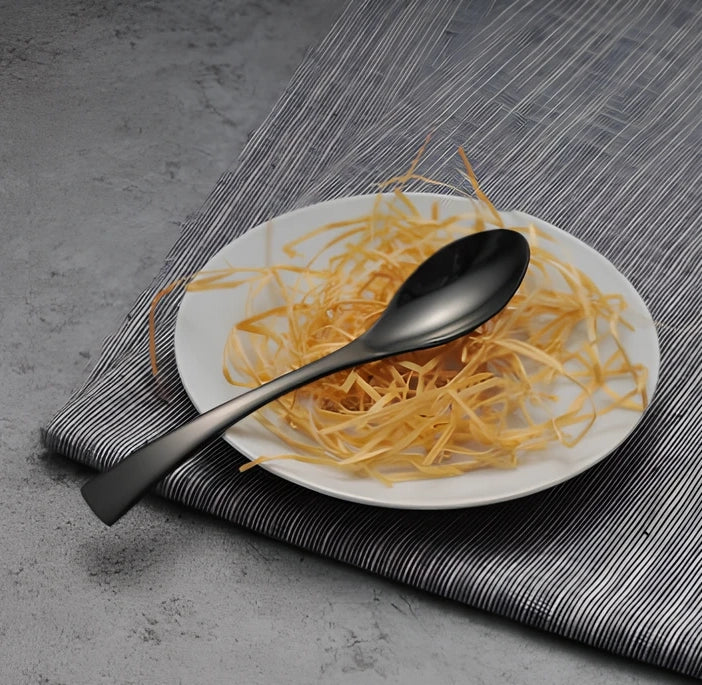 Four-piece black stainless steel cutlery set with mirror polishing showing fork, knife, coffee spoon, and soup spoon