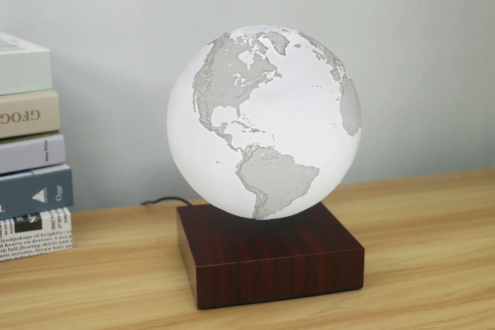 Levitating Earth or Jupiter lamp floating above base with LED illumination