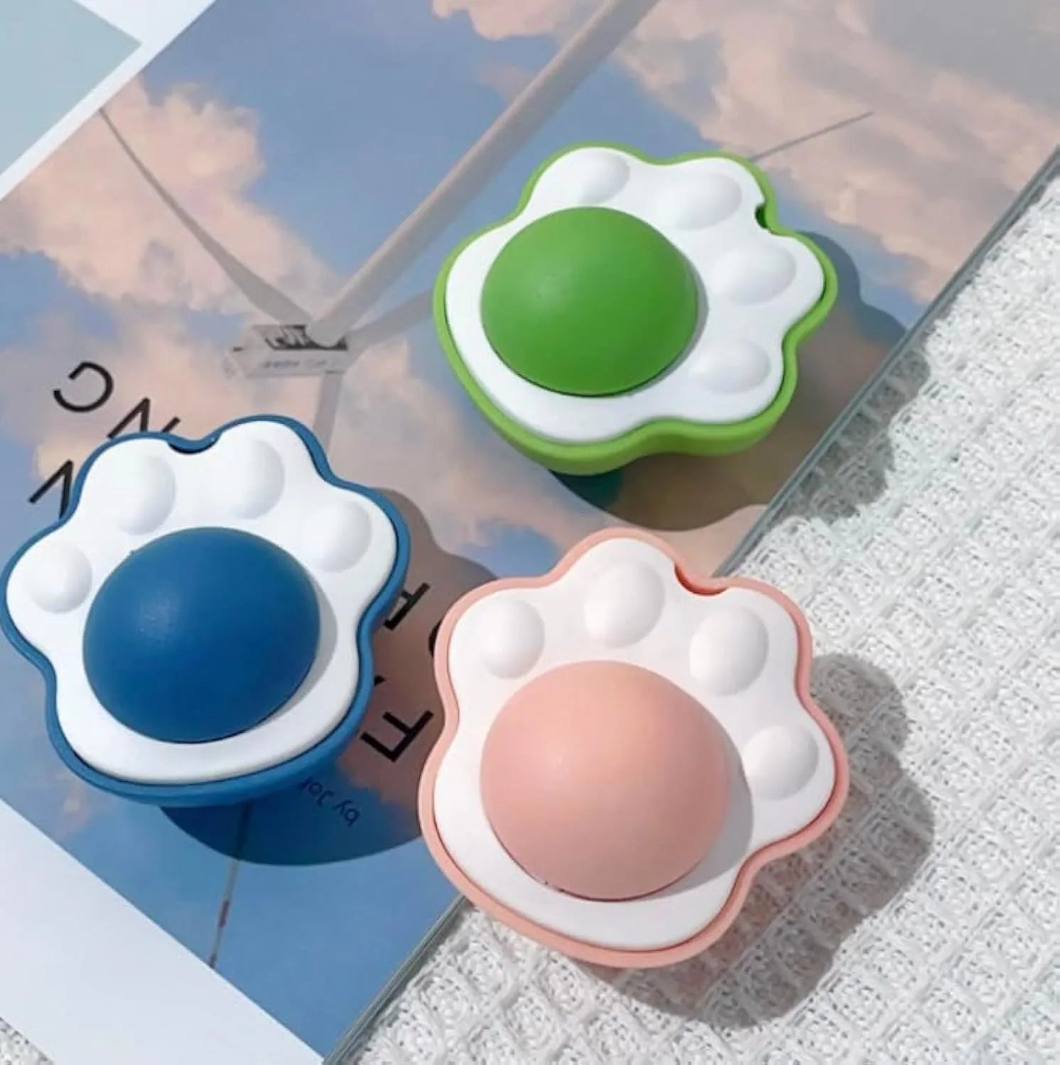 Blue catnip ball with edible vine chew surface, shown mounted on a wall for feline dental play.
