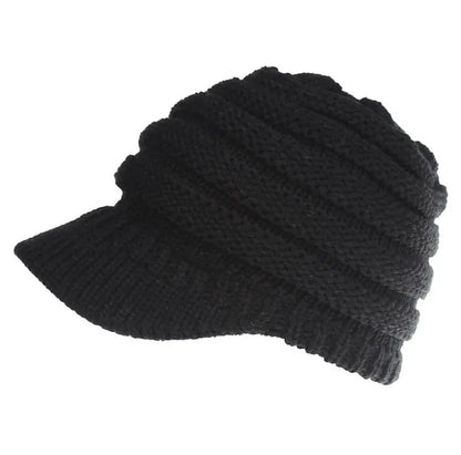 Woman wearing a light grey knitted ponytail beanie with her ponytail pulled through the hole in the back.