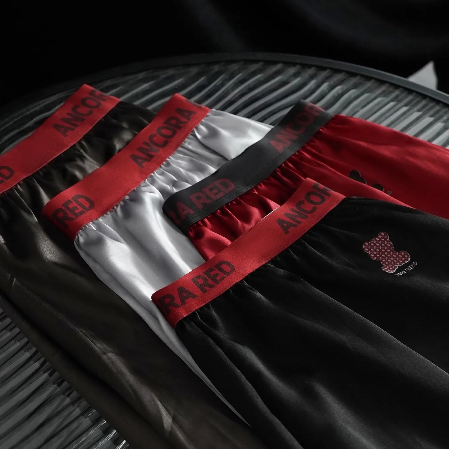 Men's solid black polyester boxer briefs with a mid-rise waistband, laid flat to show design.
