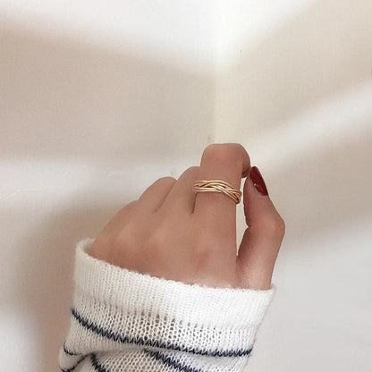 Adjustable twist metal ring in a gold tone, featuring a modern geometric design with a vintage-inspired flair.
