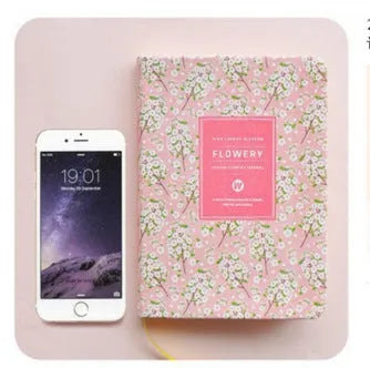 Bo Shide floral notepad with fabric-imitation leather cover in green, shown open on a desk.