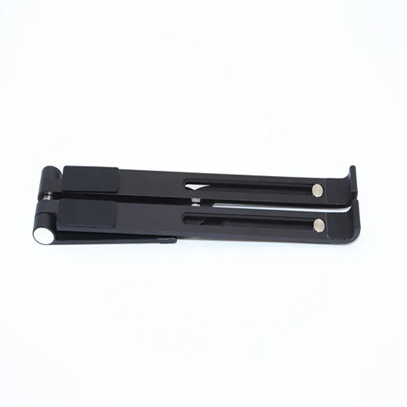Black and silver aluminum laptop stand measuring 26cm wide on a wooden desk.