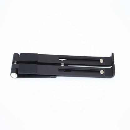 Black and silver aluminum laptop stand measuring 26cm wide on a wooden desk.