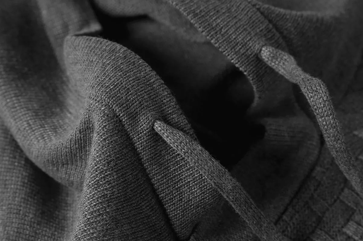 Man wearing a cotton-polyester blend hooded sweatshirt in grey, showing the front design and hood.