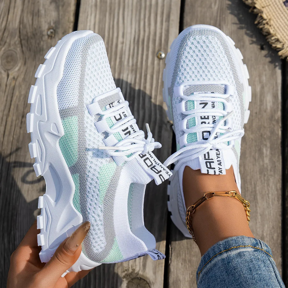 Women's Flyknit mesh lace-up sneakers in a grey colourway on a white background