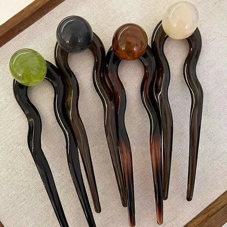 Acrylic U-shaped hair barrette with retro ball design in caramel colour