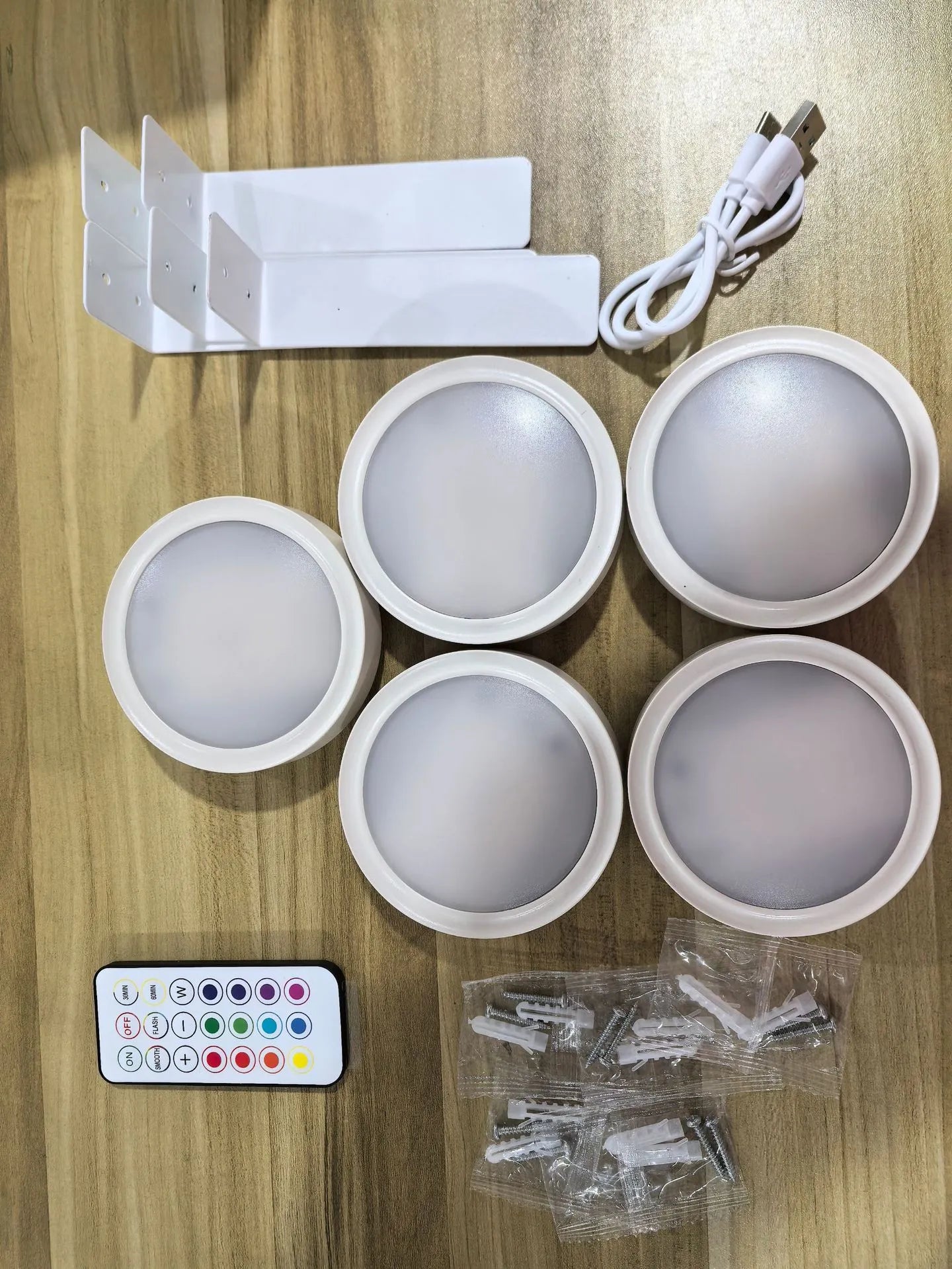 Black magnetic LED painting lamp with remote control on a white wall.