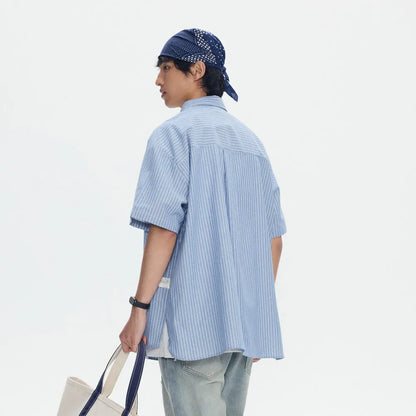 Blue and white striped loose-fitting short-sleeved overalls shirt on a hanger.