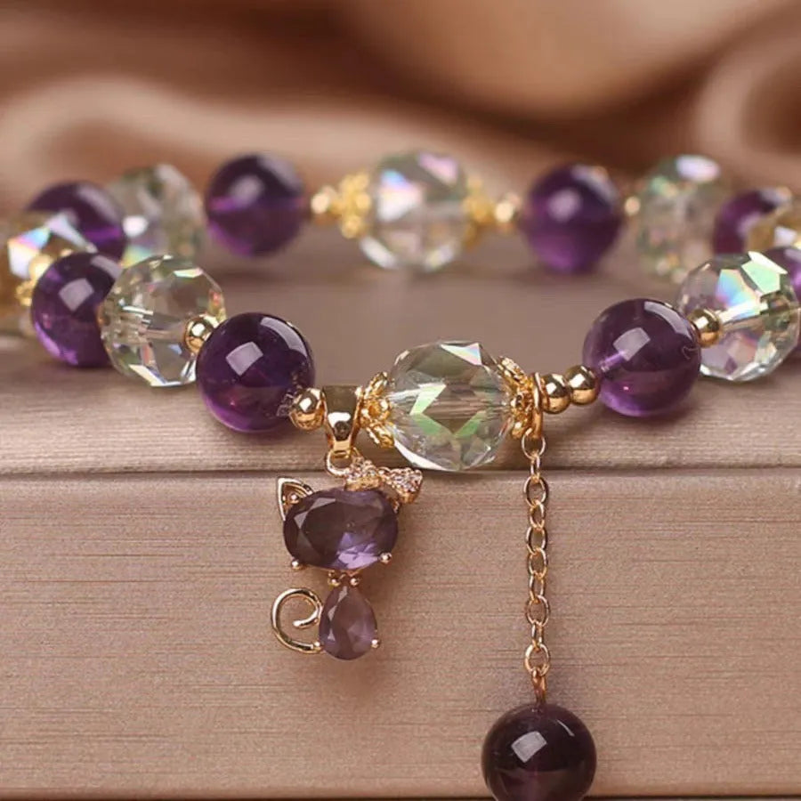 Natural purple amethyst crystal bracelet with nine-tailed fox and flower pendants on wrist.