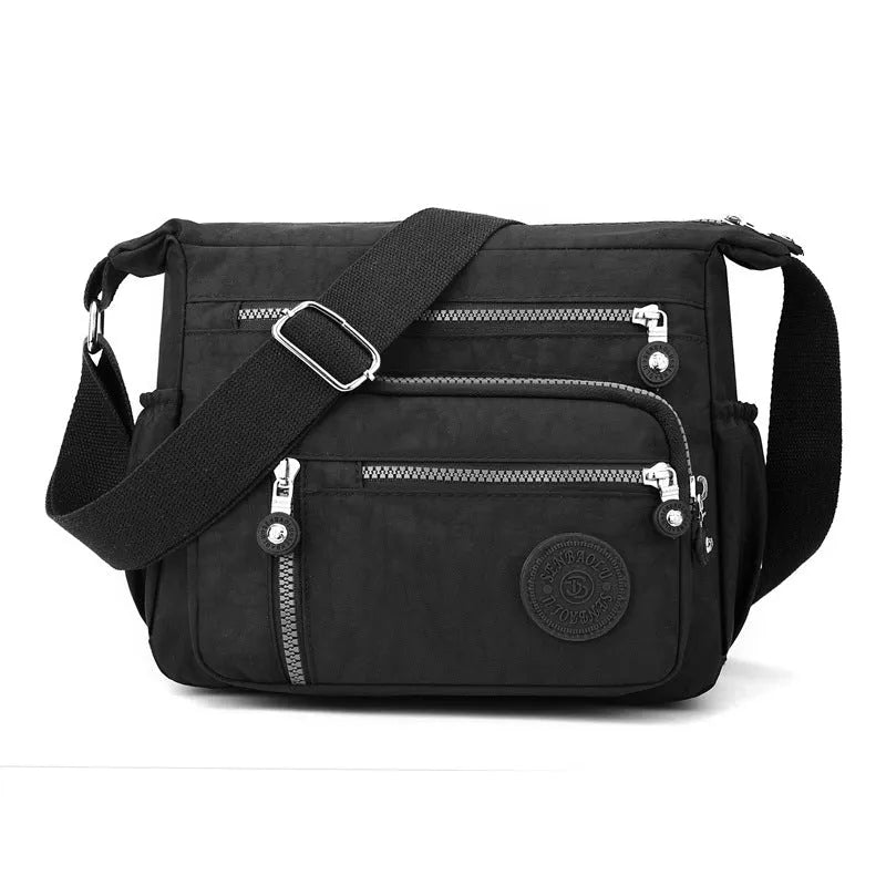 Soft grey nylon messenger bag with a single shoulder strap, shown in a square vertical shape.