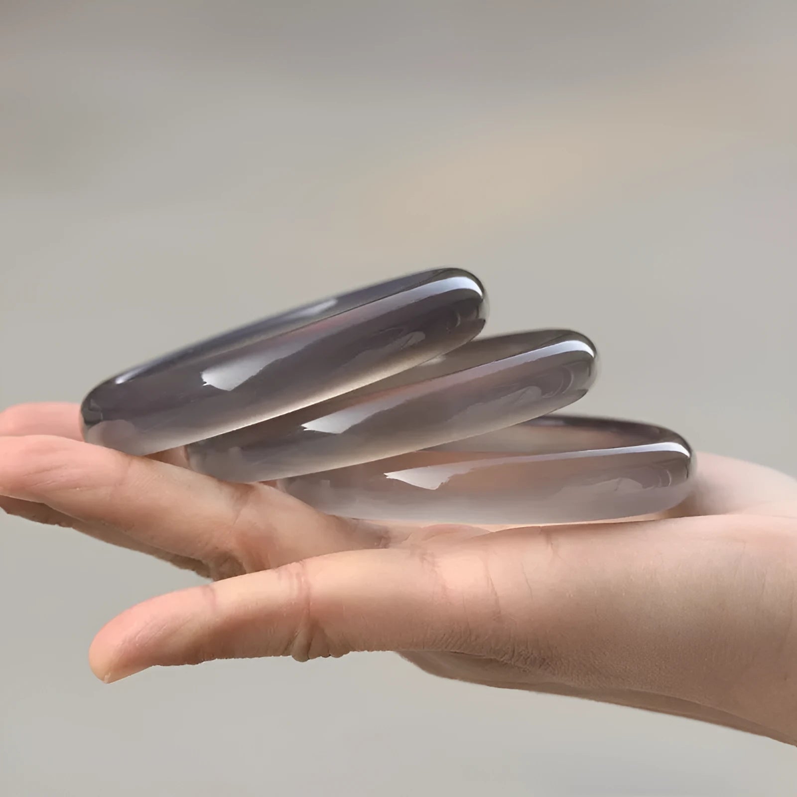 A women's bracelet made from dark grey Brazilian iced chalcedony agate, showing circle and line design elements.