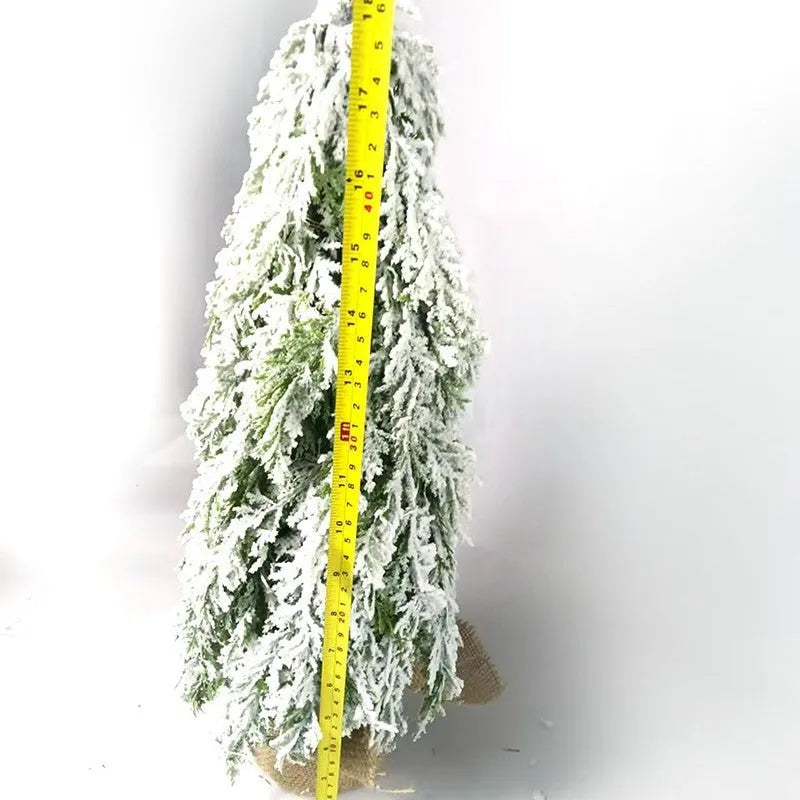 Compact 24-inch white pre-lit artificial Christmas tree with snow-covered branches on a table.