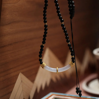 Women's Chinese style necklace with matte black agate pendant and silver ball bead chain.