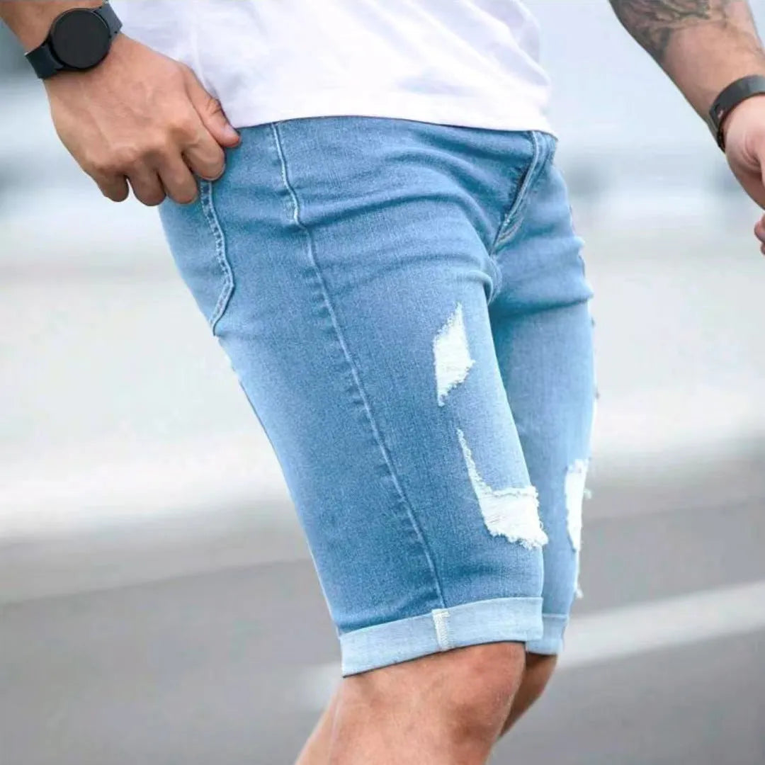 Men's sky blue denim shorts with multi-hole distressed design and a zip fly.