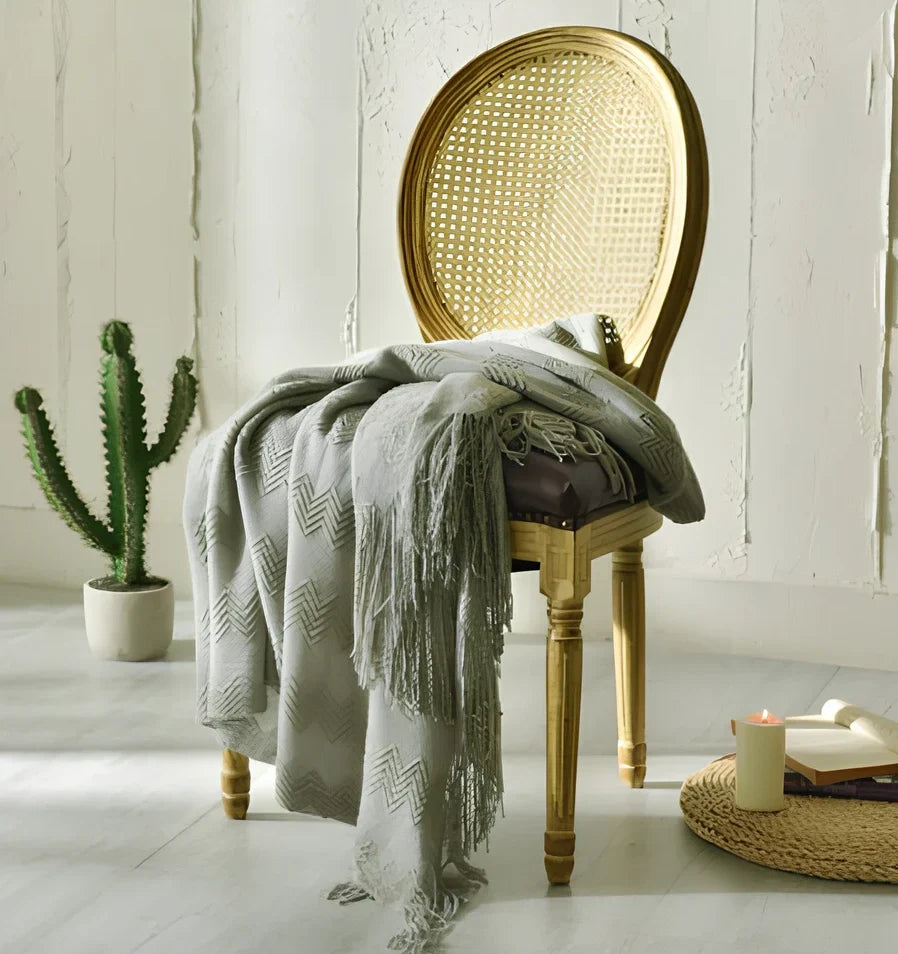 130x150cm knitted acrylic blanket with 10cm fringe detailing in beige colour draped over sofa