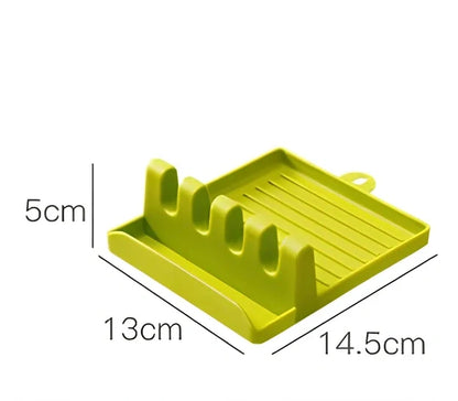 Green silicone spatula holder with four slots for kitchen utensils on countertop