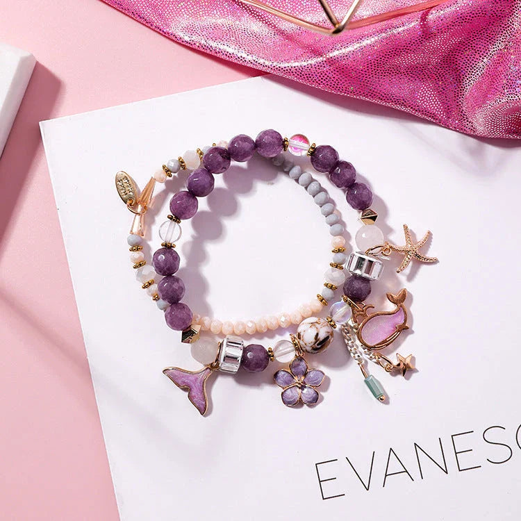 Elegant whale tail bracelet in vibrant colors with flower and starfish accents, perfect for adding a touch of coastal charm to any outfit.