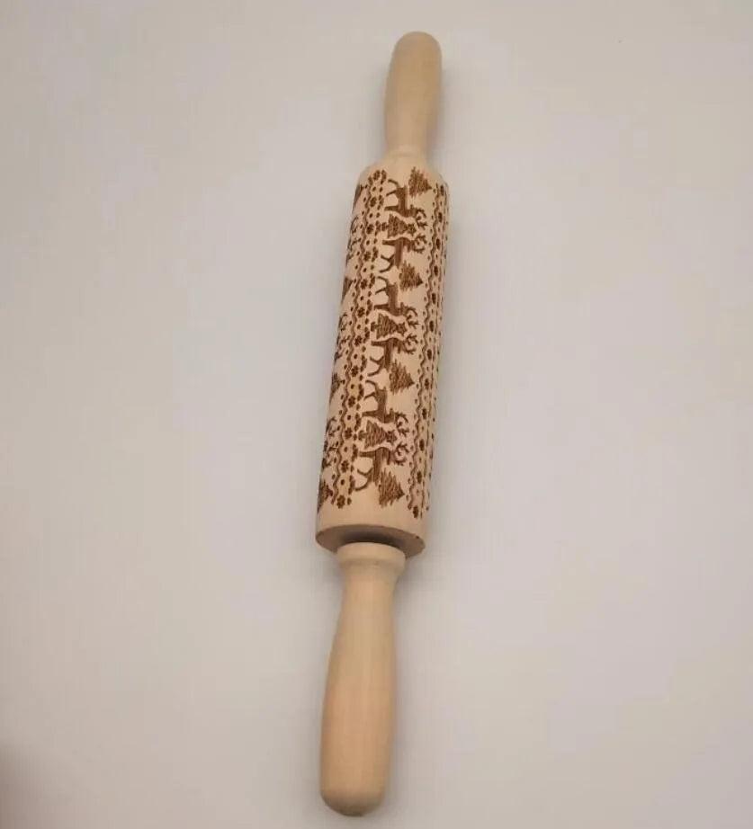 Wooden rolling pin with engraved Christmas patterns including reindeer and snowflakes on a 45cm long barrel.