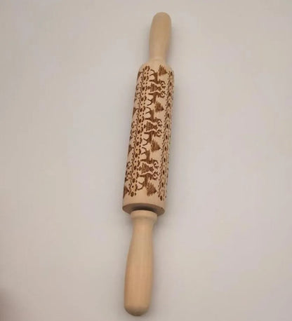Wooden rolling pin with engraved Christmas patterns including reindeer and snowflakes on a 45cm long barrel.