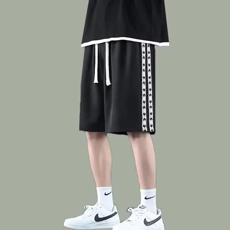 Man wearing loose-fit black baggy track pants with an elasticated waist for casual athletic wear