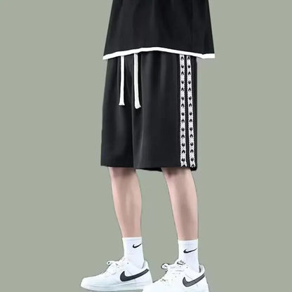 Man wearing loose-fit black baggy track pants with an elasticated waist for casual athletic wear