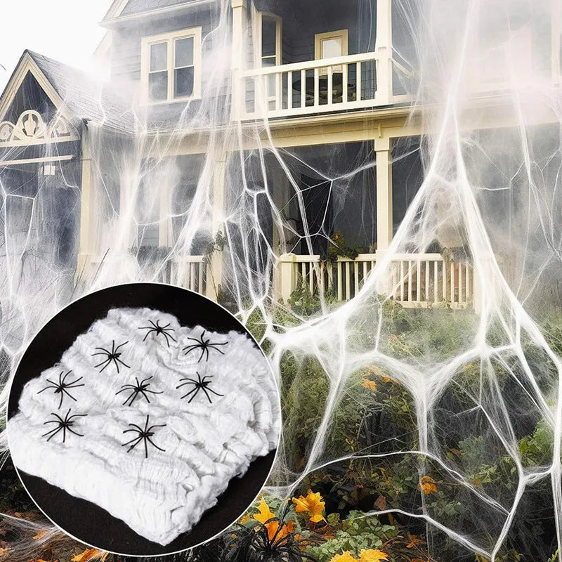 White cotton spider web Halloween decoration with multiple spiders draped over furniture for spooky atmospheric display