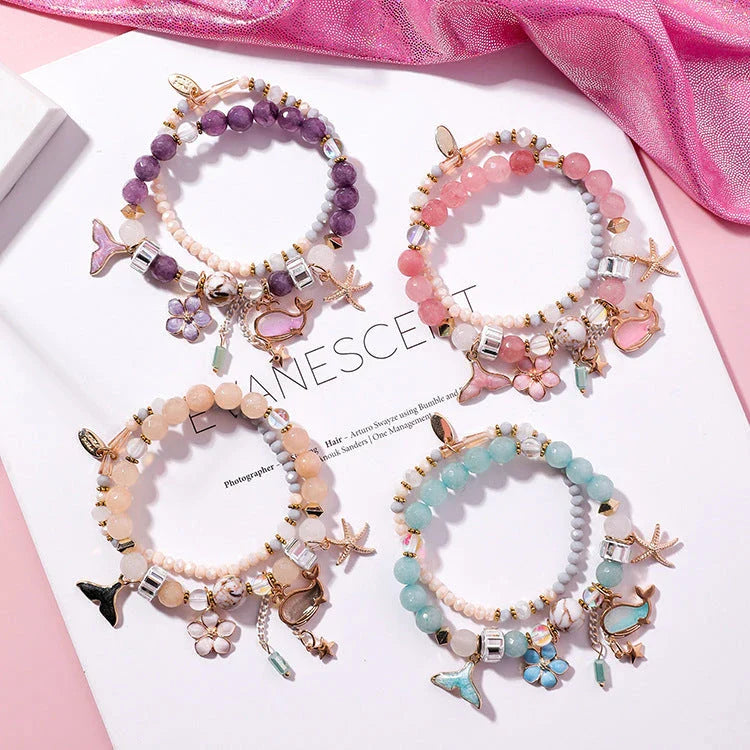 Elegant whale tail bracelet in vibrant colors with flower and starfish accents, perfect for adding a touch of coastal charm to any outfit.