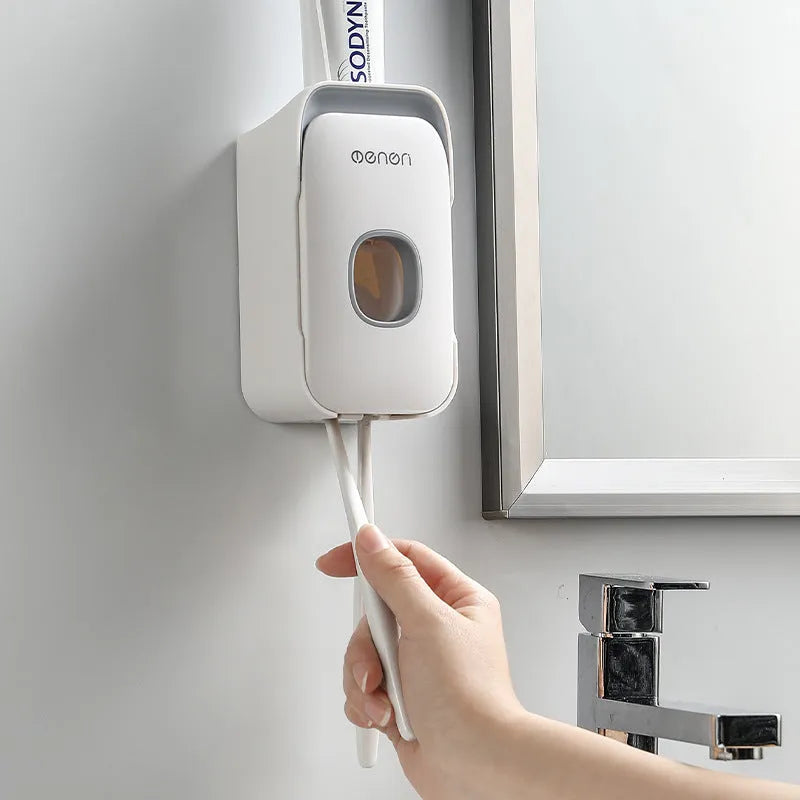 Automatic toothpaste dispenser with motion sensor and LED light in blue, grey or pink colours mounted on bathroom wall