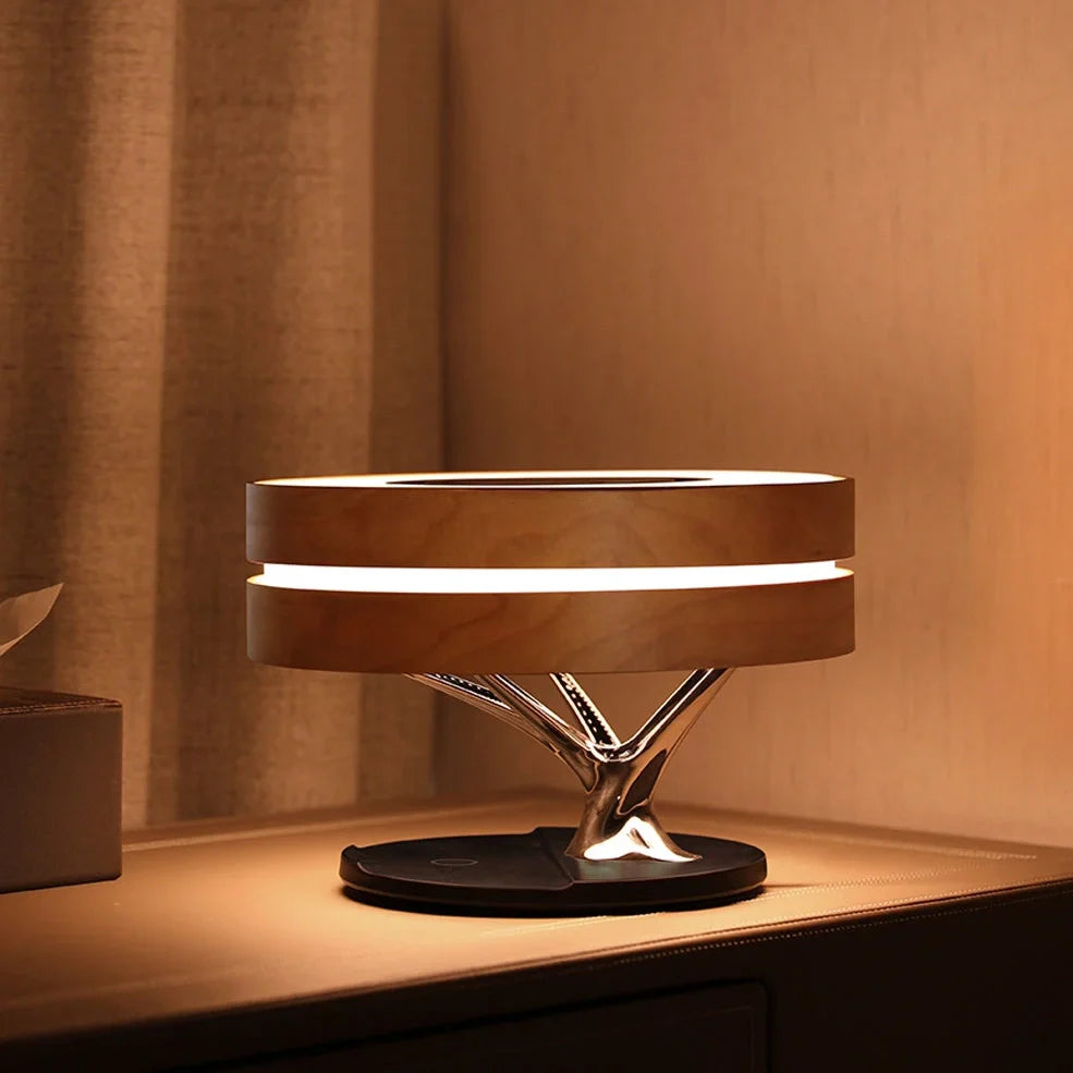 Round Bluetooth speaker with LED tree lighting and wireless charging surface in maple brown finish