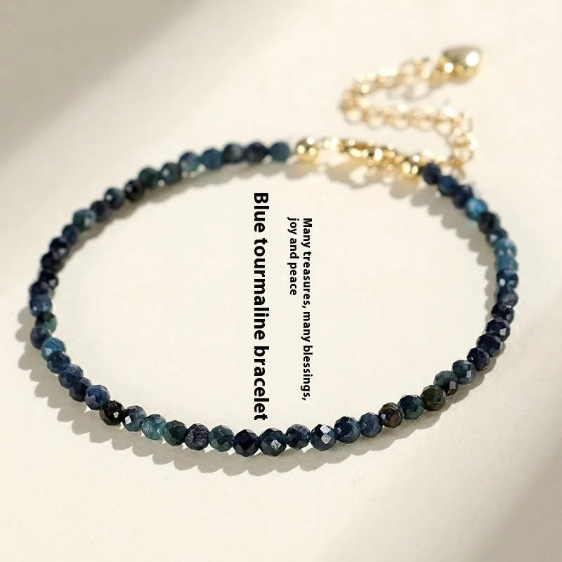 Close-up of a blue tourmaline beaded bracelet with 3mm stones and spacer beads on a wrist.