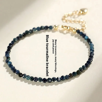 Close-up of a blue tourmaline beaded bracelet with 3mm stones and spacer beads on a wrist.