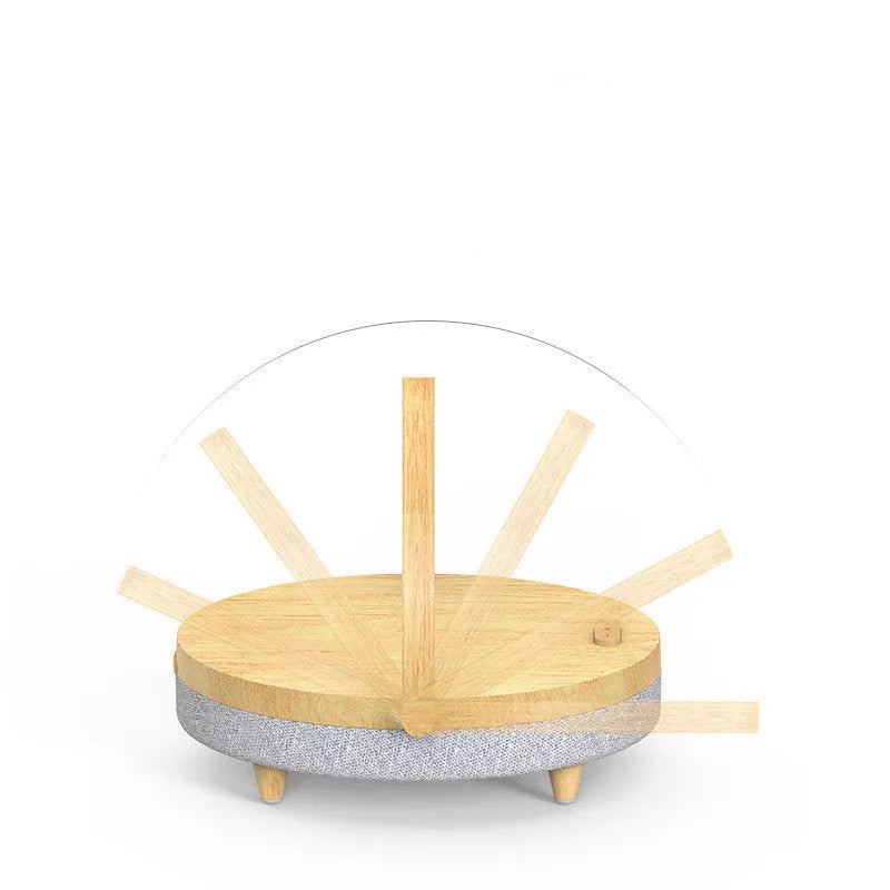 Wireless charging LED night light with Bluetooth speaker in marble pattern finish on a wooden desk.