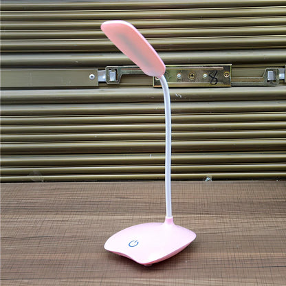 White foldable LED desk lamp with touch button and USB charging port on a desk