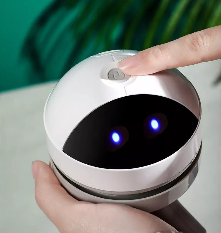 Compact USB charging wireless mini portable robot desktop vacuum cleaner on a desk