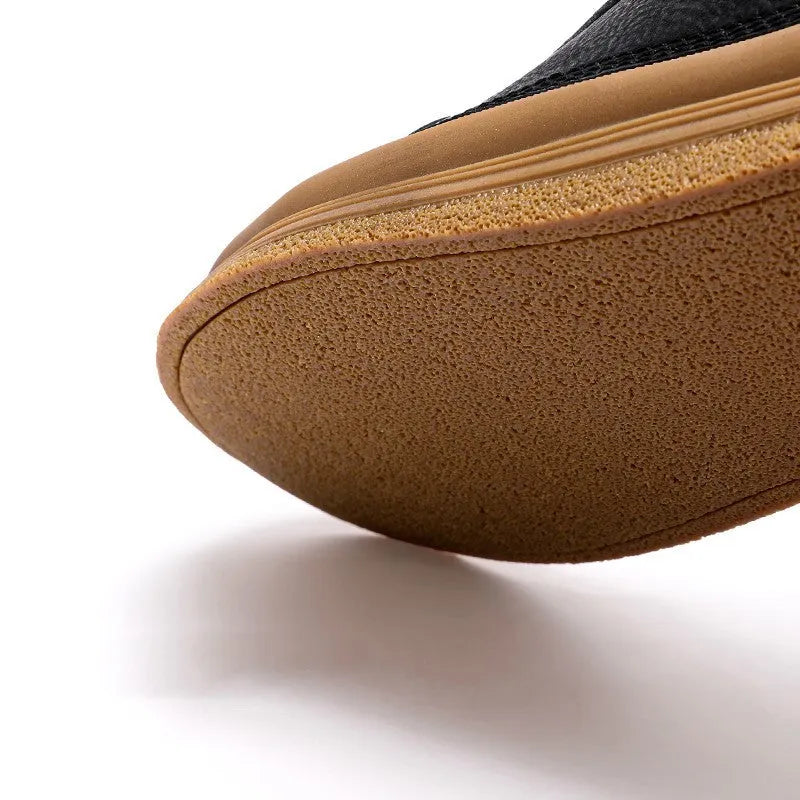 Men's black casual shoes with round toe, lanyard closure, and soft rubber soles on a neutral background