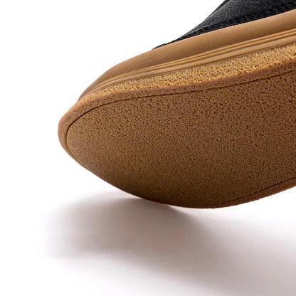 Men's black casual shoes with round toe, lanyard closure, and soft rubber soles on a neutral background