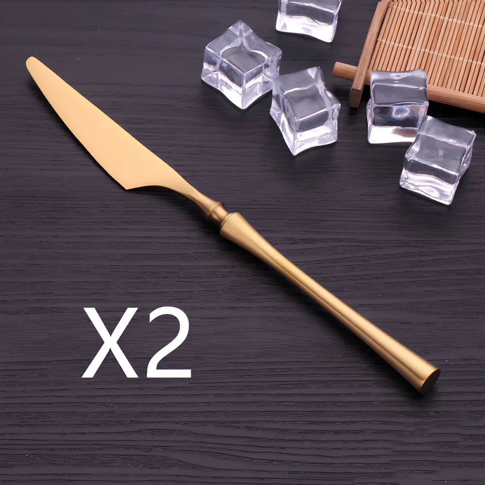 Four-piece stainless steel cutlery set showing main knife, fork, spoon, and teaspoon with mirror finish