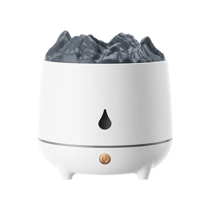 White volcano-shaped humidifier with USB cable on a wooden table, emitting mist.