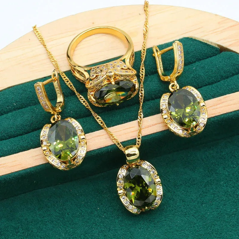 Olive green zircon jewellery suit set showing necklace with snake bone chain, matching earrings, and ring on a display.