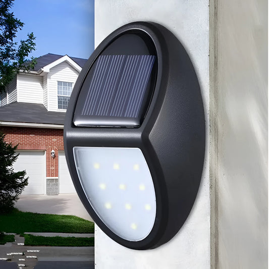 Black rectangular LED solar wall light mounted on an outdoor wall with a visible solar panel.